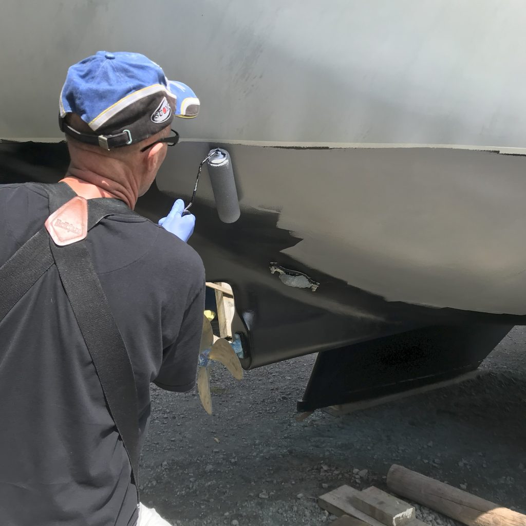 Les applying primer on the hull of Ocean Strider. 